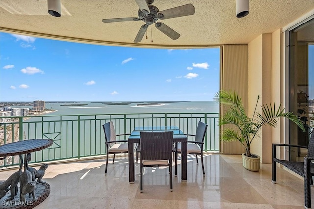 balcony with a water view and ceiling fan