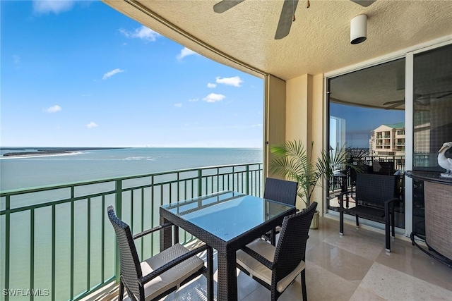 balcony featuring a water view and ceiling fan