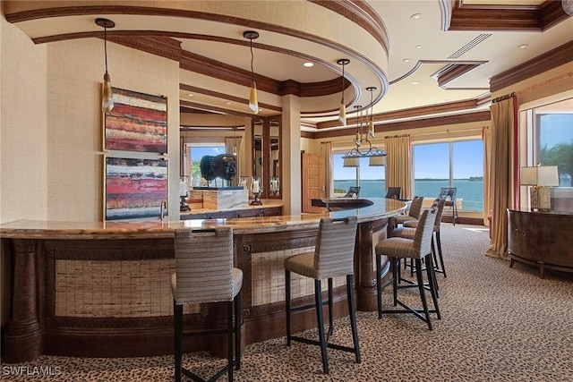 bar with a water view, carpet flooring, and crown molding