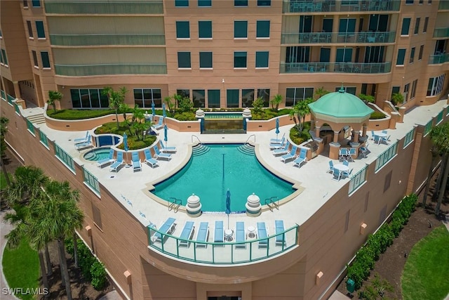 view of swimming pool featuring a hot tub and a patio area