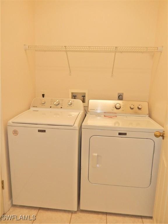 laundry room featuring light tile patterned floors and washer and clothes dryer