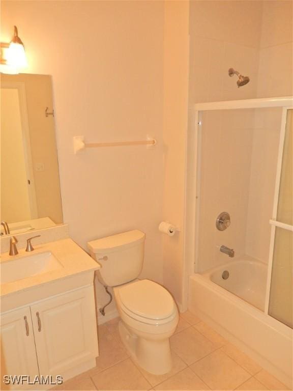 full bathroom with tiled shower / bath combo, vanity, toilet, and tile patterned flooring