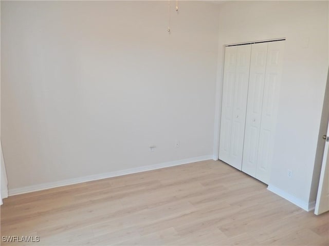 unfurnished bedroom with light hardwood / wood-style flooring and a closet