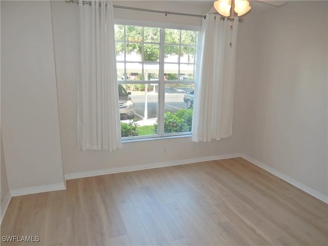 spare room with plenty of natural light, light hardwood / wood-style flooring, and ceiling fan