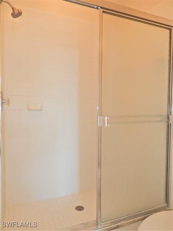 bathroom with toilet and an enclosed shower