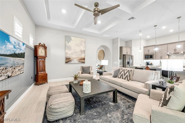 living room featuring coffered ceiling, ceiling fan, and light hardwood / wood-style flooring