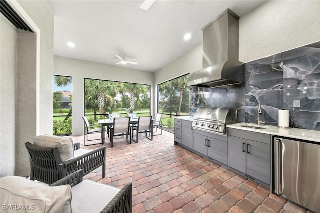 view of patio with an outdoor kitchen, grilling area, ceiling fan, and sink