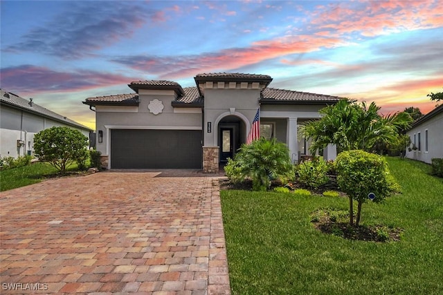 mediterranean / spanish home featuring a garage and a yard