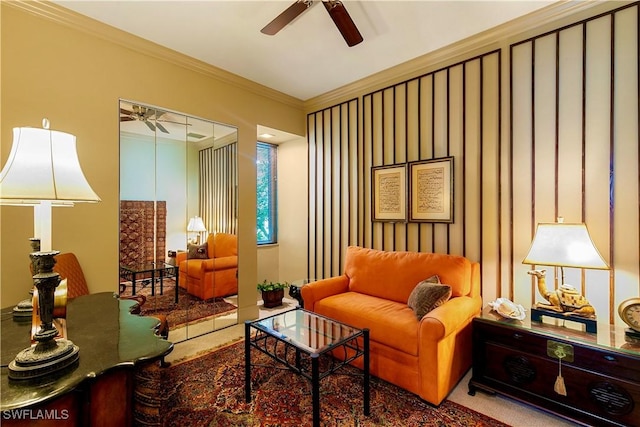 sitting room with ceiling fan, carpet flooring, and ornamental molding