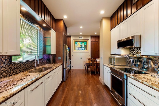 kitchen featuring sink, light stone counters, white cabinetry, stainless steel appliances, and dark hardwood / wood-style flooring