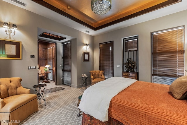 bedroom with light carpet and a raised ceiling