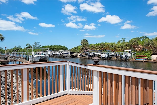 wooden deck featuring a water view, a boat dock, and boat lift