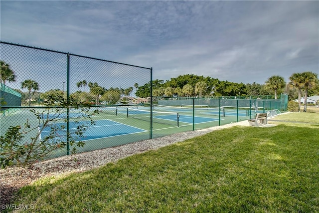 view of tennis court featuring a lawn