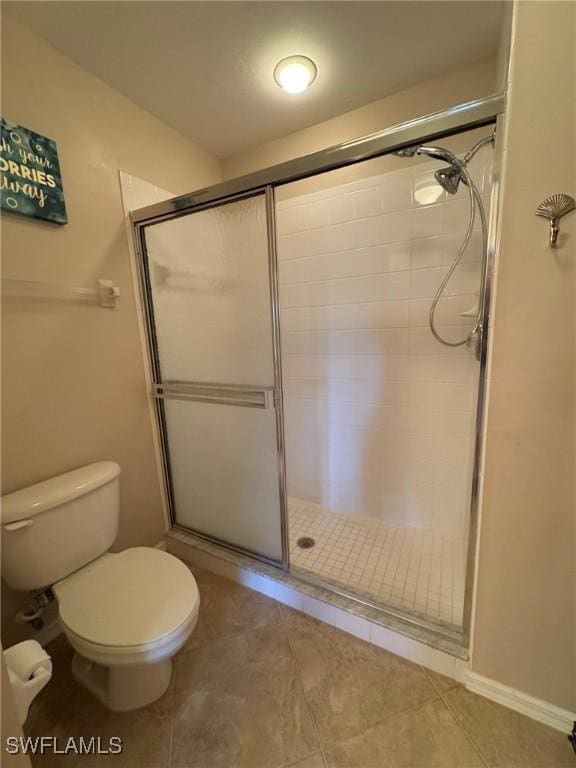 bathroom featuring toilet and a shower with shower door