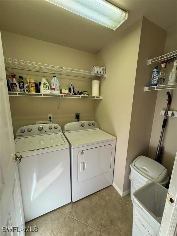 laundry area featuring washing machine and dryer and light tile patterned flooring