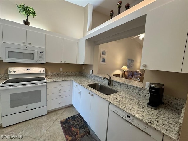 kitchen with sink, white cabinets, a high ceiling, light tile patterned flooring, and white appliances