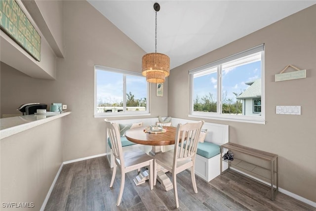 dining area with breakfast area, dark hardwood / wood-style flooring, and vaulted ceiling