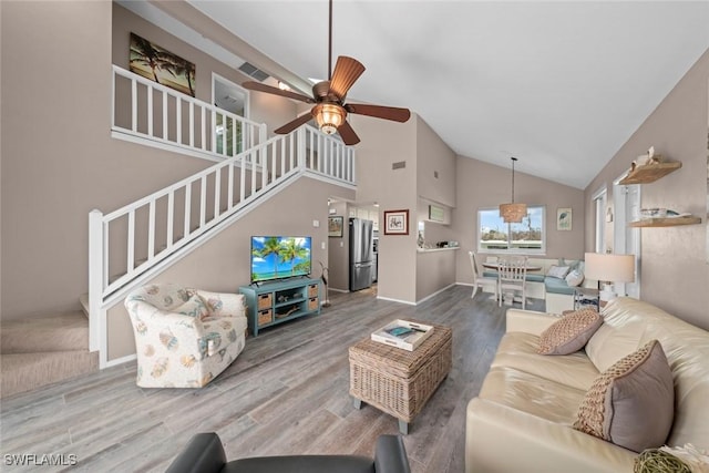 living room with ceiling fan, wood-type flooring, and high vaulted ceiling
