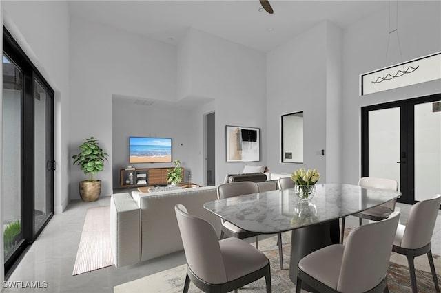 dining room with a towering ceiling and french doors