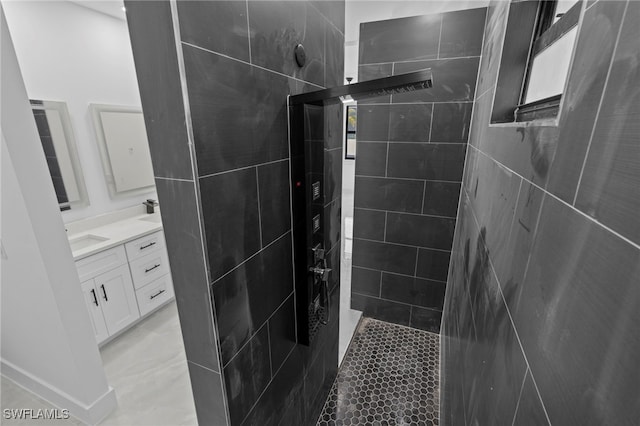 bathroom featuring a tile shower and vanity