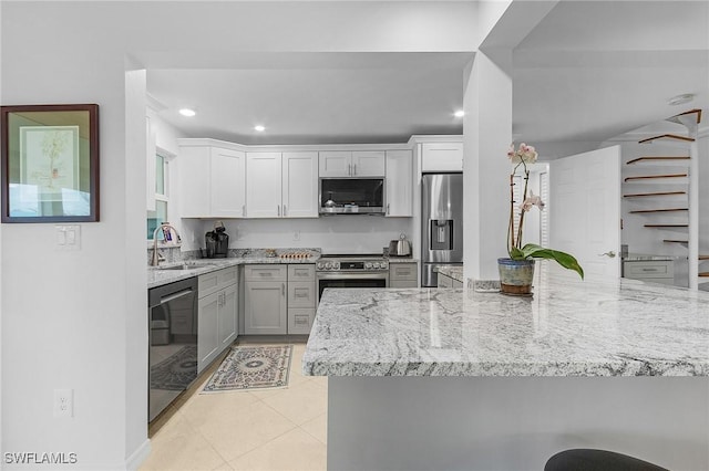 kitchen with light stone countertops, light tile patterned floors, stainless steel appliances, and sink