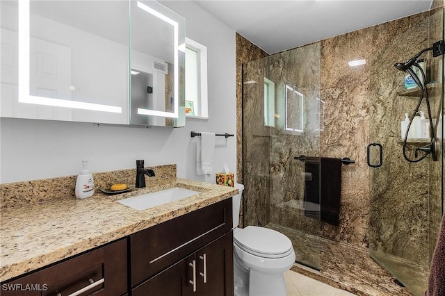 bathroom featuring vanity, an enclosed shower, and toilet