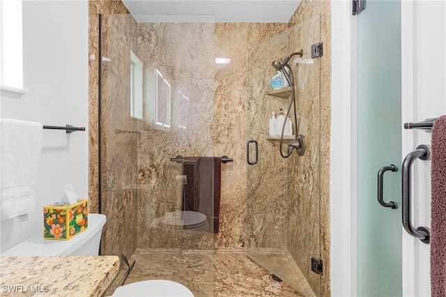 bathroom featuring toilet and a shower with shower door