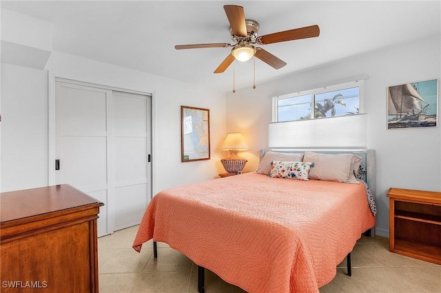 tiled bedroom with ceiling fan and a closet