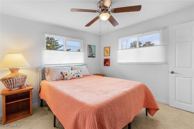 tiled bedroom with ceiling fan and multiple windows