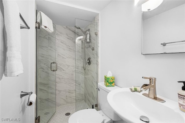 bathroom featuring an enclosed shower, sink, and toilet