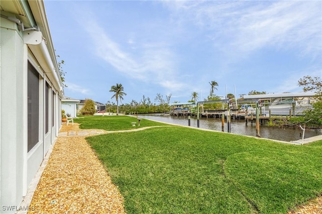 view of dock with a lawn and a water view