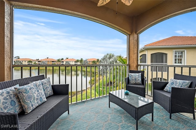 balcony with ceiling fan and a water view