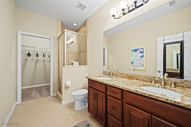 bathroom featuring vanity, toilet, tile patterned floors, and a shower with shower door