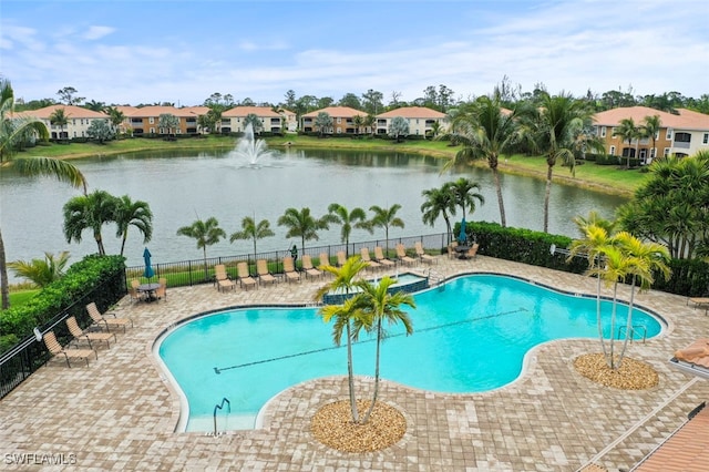 view of swimming pool with pool water feature and a water view