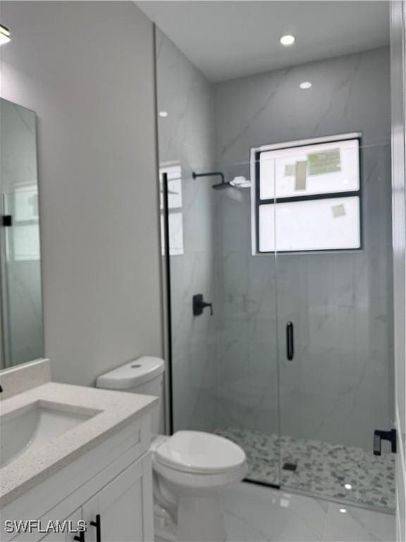 full bath featuring marble finish floor, a marble finish shower, recessed lighting, toilet, and vanity