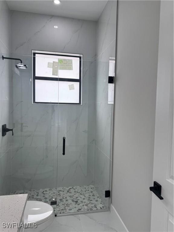 full bath with toilet, marble finish floor, a marble finish shower, and vanity