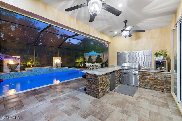 view of patio with area for grilling, exterior bar, ceiling fan, a lanai, and a grill