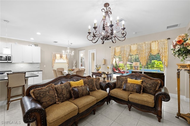 living room with a chandelier, light tile patterned flooring, visible vents, and baseboards