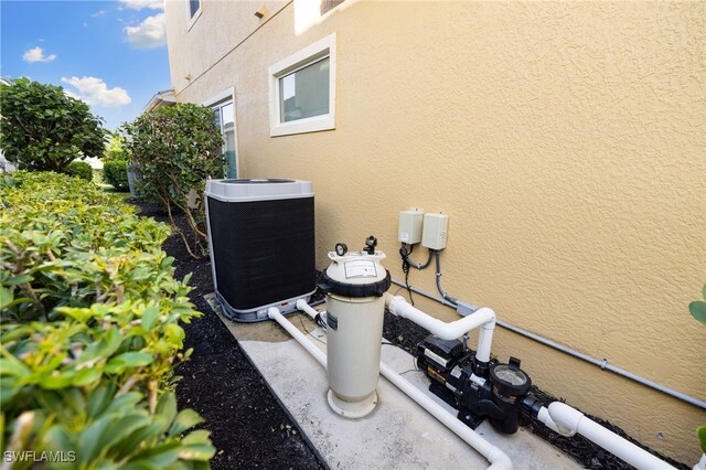 details featuring central AC unit and stucco siding