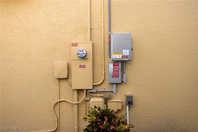 exterior details featuring electric meter and stucco siding