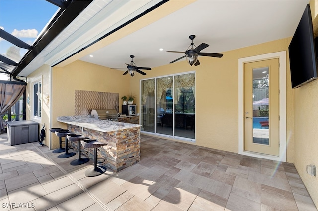 view of patio / terrace featuring exterior kitchen, ceiling fan, outdoor dry bar, and grilling area