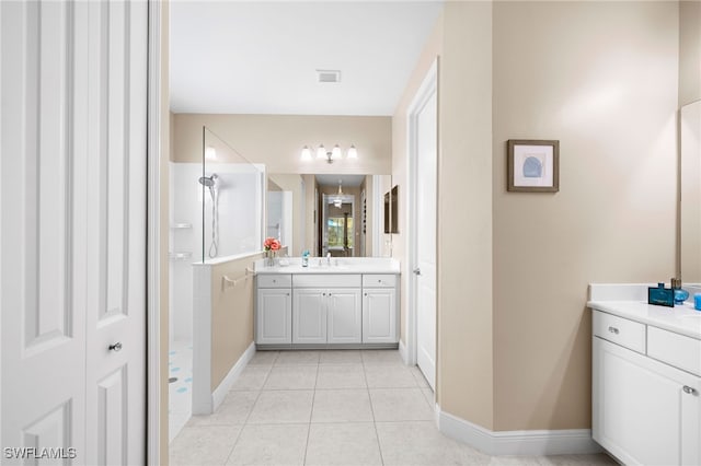 bathroom with visible vents, tile patterned floors, walk in shower, vanity, and a closet