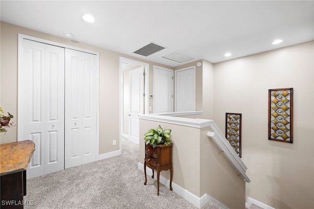 hall with baseboards, recessed lighting, an upstairs landing, and light colored carpet