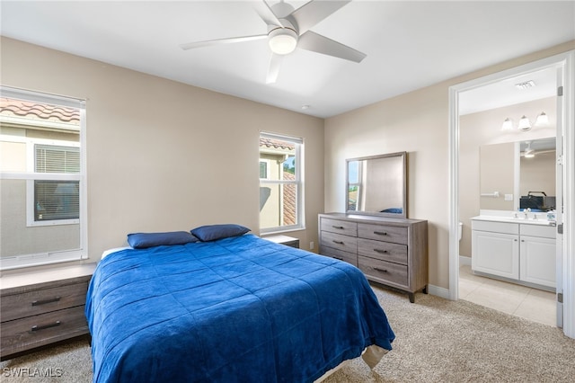 bedroom featuring light carpet, baseboards, connected bathroom, a ceiling fan, and a sink