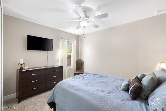 bedroom with light carpet, ceiling fan, and baseboards