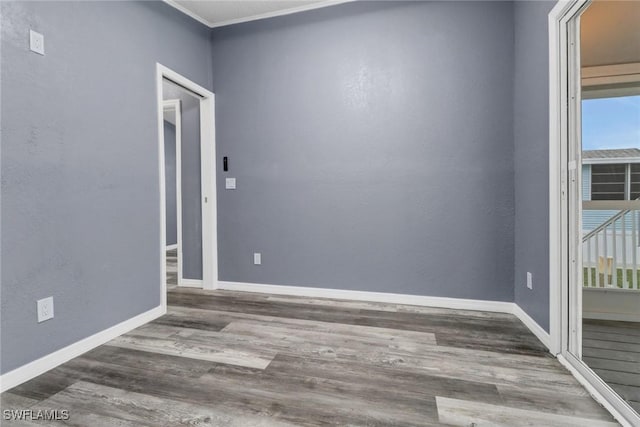 spare room with dark hardwood / wood-style flooring and crown molding