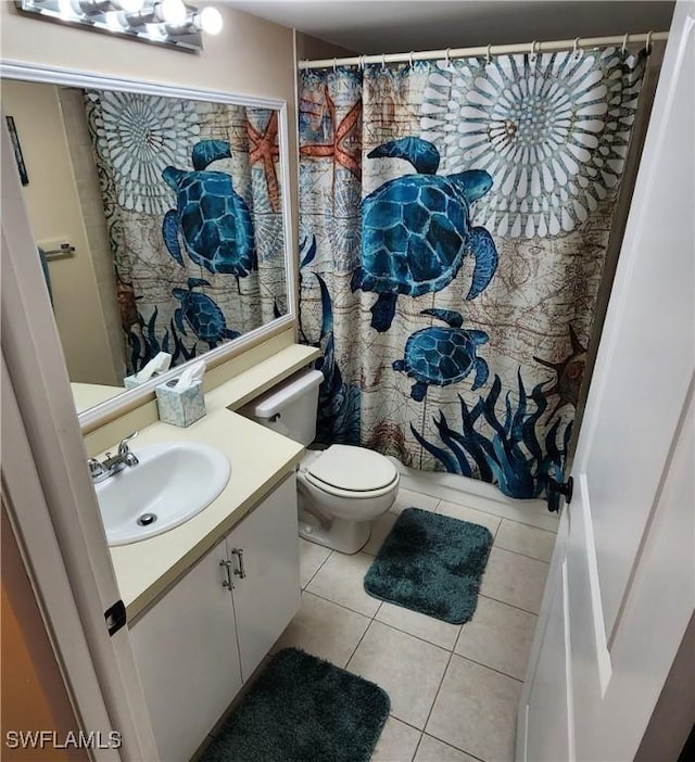 bathroom with toilet, tile patterned floors, and vanity