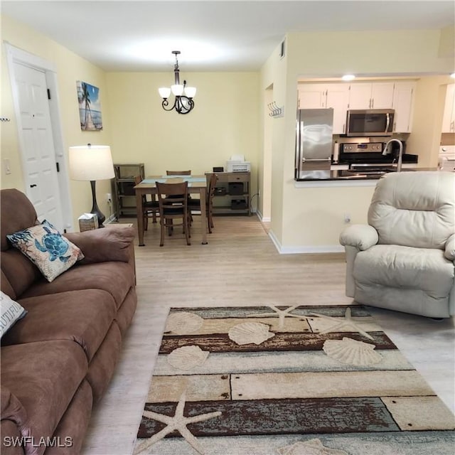 living room with light wood-type flooring and a chandelier