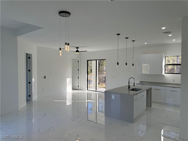 kitchen with sink, hanging light fixtures, and white cabinets