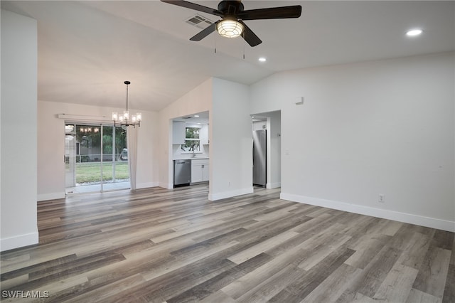 unfurnished living room with ceiling fan with notable chandelier, light wood-type flooring, and vaulted ceiling